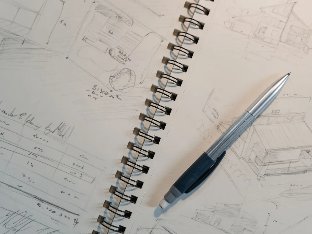 Stock photo: Mechanical pencil on a spiral sketchbook with pencil drawings and planning notes