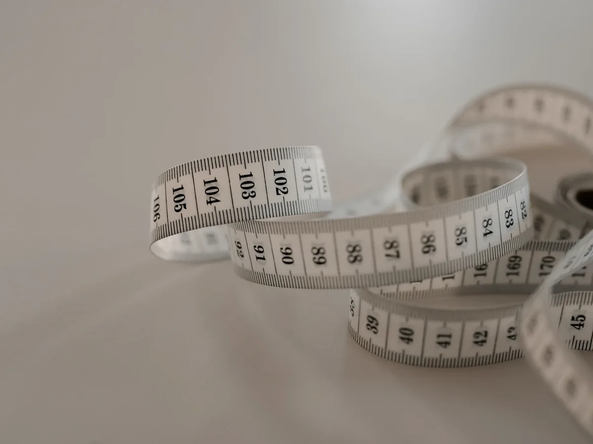 Stock photo: Loosely coiled cloth tape measure on a light surface